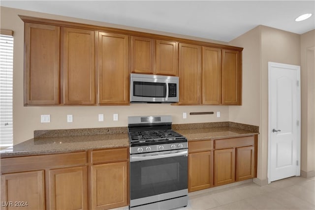 kitchen featuring light stone countertops, light tile patterned floors, and appliances with stainless steel finishes