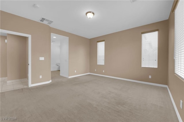 unfurnished room featuring light carpet