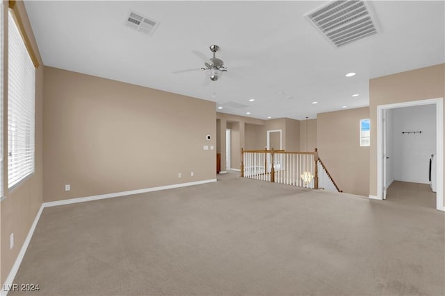 empty room featuring ceiling fan and light colored carpet