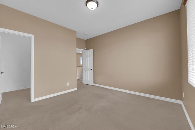 unfurnished bedroom with light colored carpet and a spacious closet