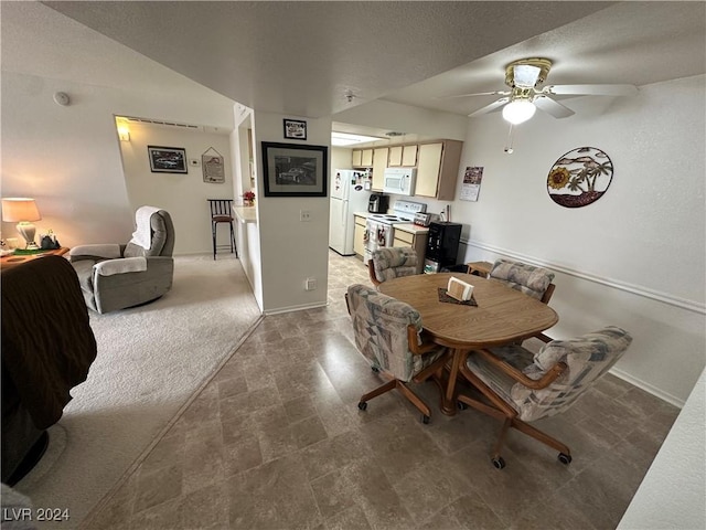 dining space with carpet floors and ceiling fan