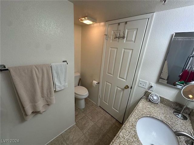 bathroom with tile patterned flooring, vanity, and toilet