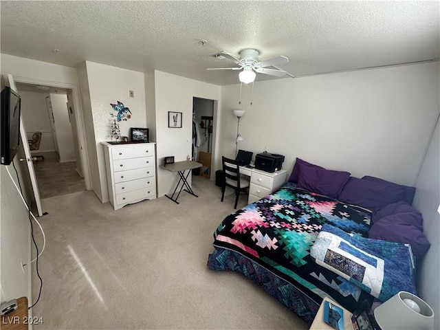 bedroom with carpet, a textured ceiling, and ceiling fan