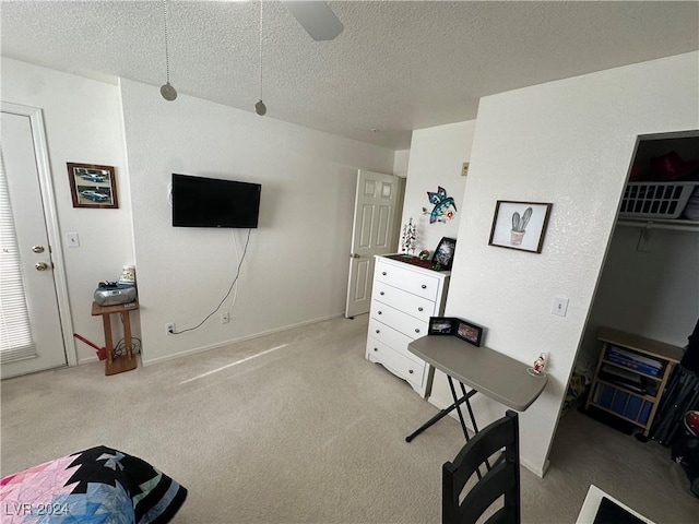 interior space featuring ceiling fan, light colored carpet, and a textured ceiling