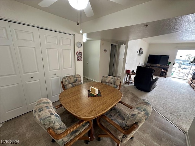 carpeted dining space with ceiling fan