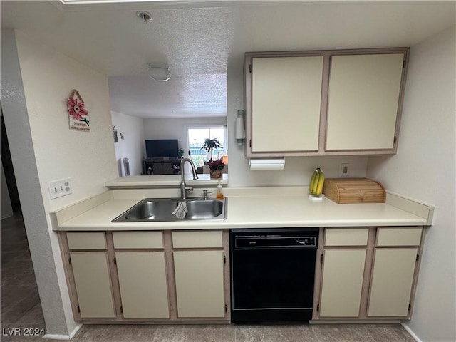 kitchen featuring a textured ceiling, black dishwasher, cream cabinets, and sink