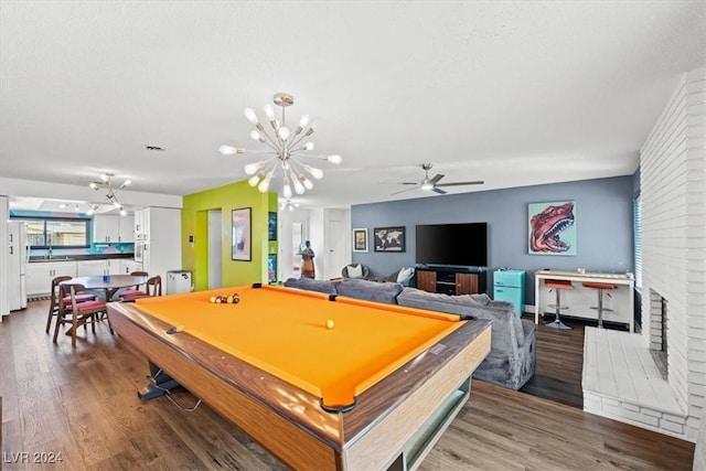 rec room with sink, billiards, wood-type flooring, a fireplace, and ceiling fan with notable chandelier