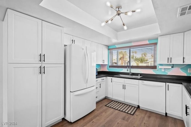 kitchen featuring white cabinets, white appliances, sink, and a tray ceiling