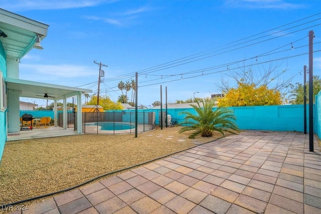 view of patio / terrace featuring a fenced in pool and ceiling fan