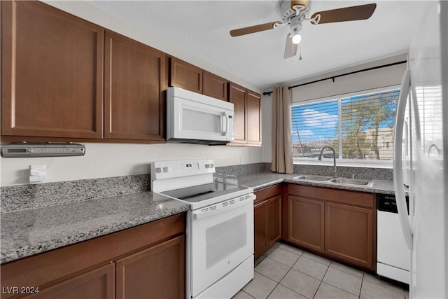 kitchen featuring white appliances, sink, ceiling fan, light tile patterned floors, and light stone counters