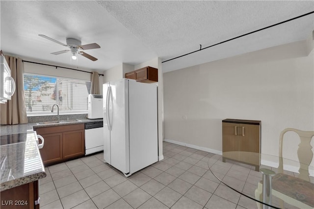 kitchen with light tile patterned flooring, white appliances, ceiling fan, and sink