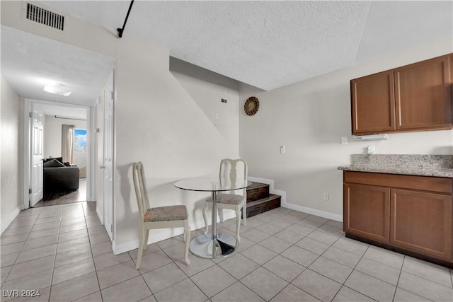 dining space featuring light tile patterned floors and a textured ceiling