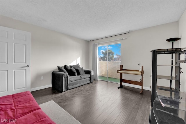 living room with dark hardwood / wood-style flooring and a textured ceiling