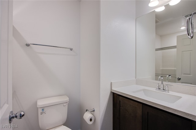 bathroom featuring walk in shower, vanity, and toilet