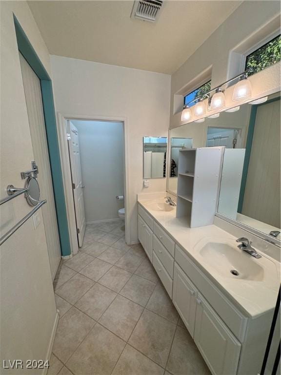 bathroom with tile patterned flooring, vanity, and toilet