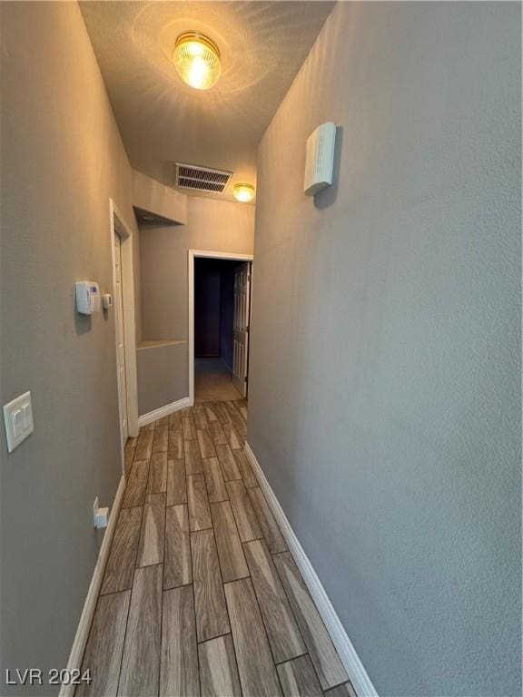 corridor with hardwood / wood-style floors