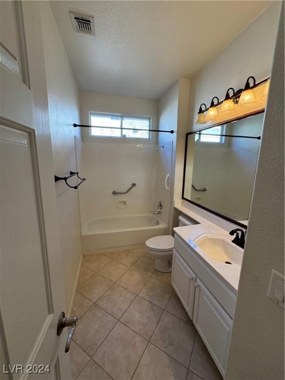 full bathroom featuring vanity, tile patterned floors, toilet, a textured ceiling, and shower / bathtub combination