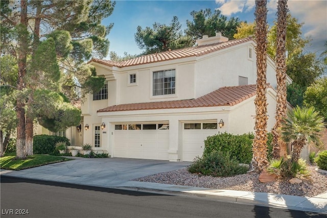 mediterranean / spanish home with a garage