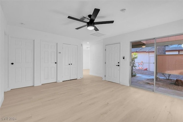 unfurnished bedroom with access to outside, ceiling fan, light hardwood / wood-style floors, and two closets