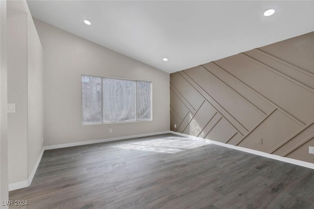 unfurnished room featuring wood-type flooring and lofted ceiling