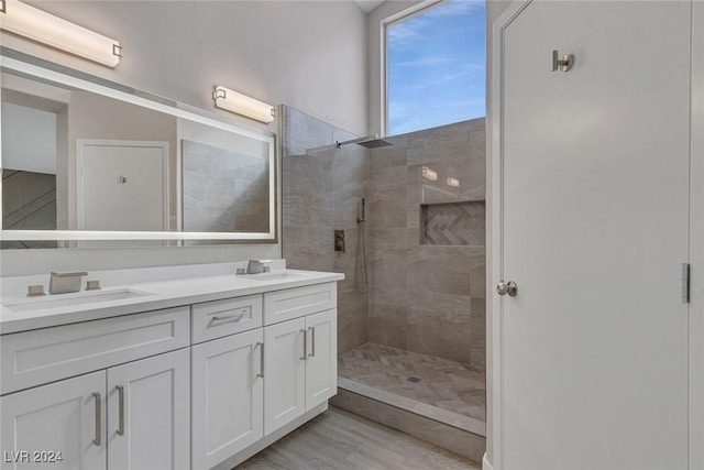 bathroom featuring vanity, wood-type flooring, and tiled shower