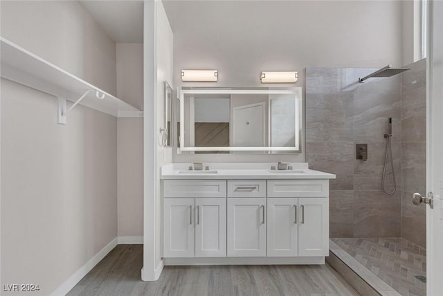 bathroom featuring hardwood / wood-style floors, vanity, and tiled shower