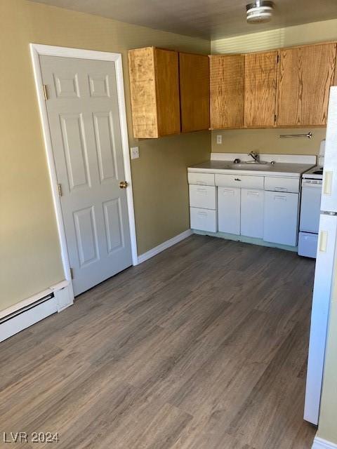 kitchen featuring dark hardwood / wood-style flooring, white range, a baseboard heating unit, sink, and white cabinets