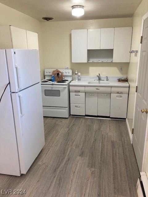 kitchen with white appliances, white cabinetry, dark wood-type flooring, and sink