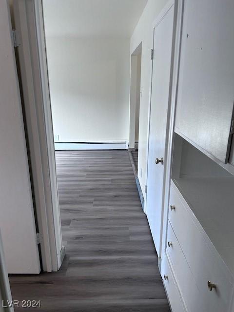 hall featuring baseboard heating and dark wood-type flooring