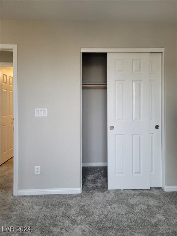 unfurnished bedroom with a closet and dark carpet