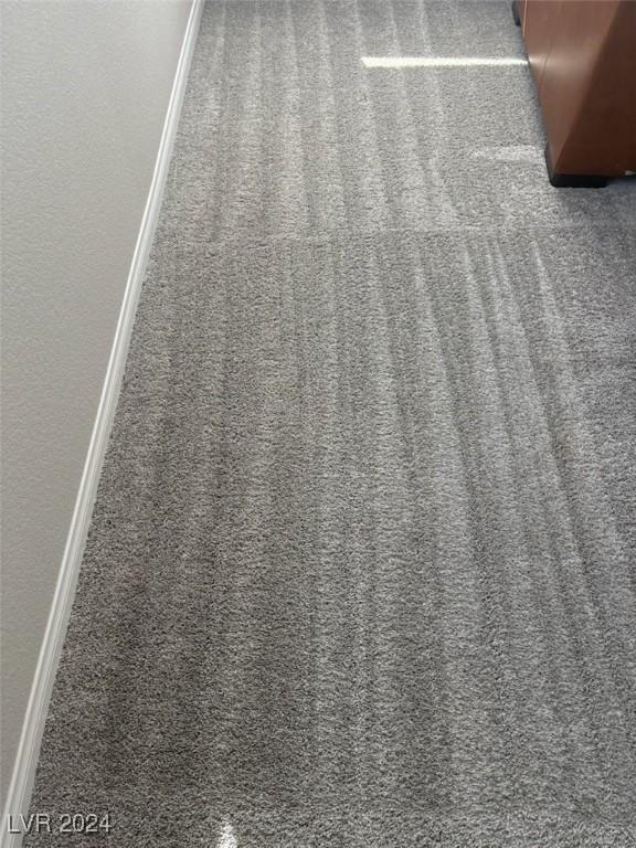 details with baseboards, a textured wall, and carpet