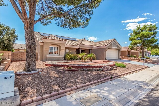 8705 Villa Ridge Dr, Las Vegas, NV 89134 - mediterranean / spanish-style home featuring a tiled roof, stucco siding, driveway, a garage, and roof mounted solar panels