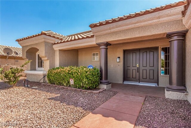 8705 Villa Ridge Dr, Las Vegas, NV 89134 - view of exterior entry with stucco siding and a tiled roof