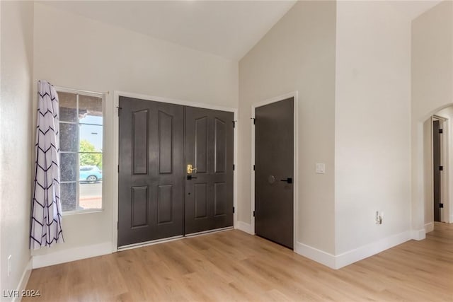 entrance foyer featuring light wood-type flooring and high vaulted ceiling