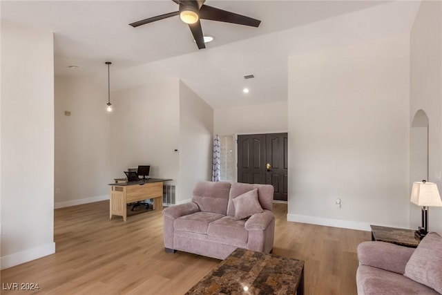 living room featuring vaulted ceiling, light hardwood / wood-style flooring, and ceiling fan