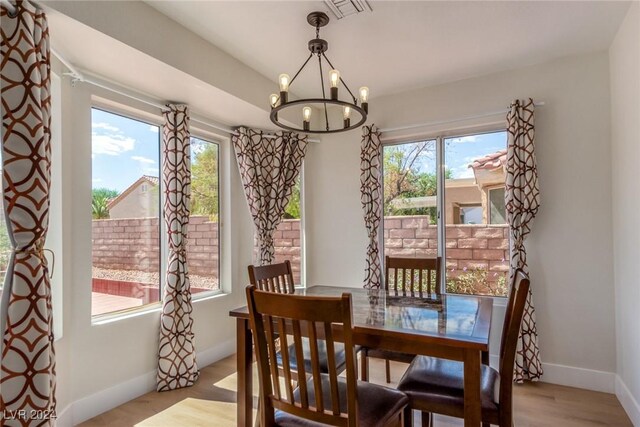 8705 Villa Ridge Dr, Las Vegas, NV 89134 - dining area with a chandelier, healthy amount of natural light, and wood finished floors