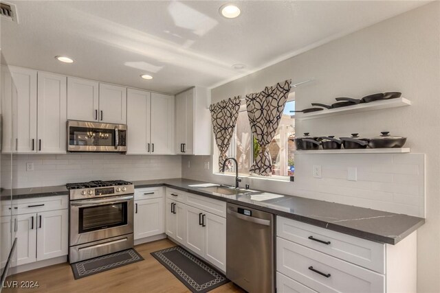 8705 Villa Ridge Dr, Las Vegas, NV 89134 - kitchen featuring stainless steel appliances, dark countertops, backsplash, white cabinets, and recessed lighting