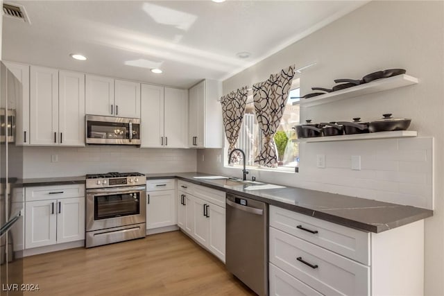 8705 Villa Ridge Dr, Las Vegas, NV 89134 - kitchen featuring appliances with stainless steel finishes, dark countertops, white cabinets, and recessed lighting
