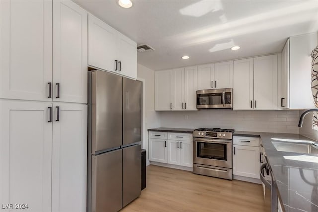 8705 Villa Ridge Dr, Las Vegas, NV 89134 - kitchen featuring appliances with stainless steel finishes, white cabinetry, recessed lighting, backsplash, and light wood finished floors