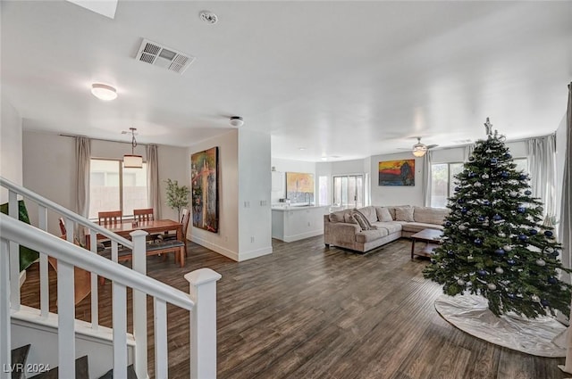 living room featuring dark hardwood / wood-style flooring, a wealth of natural light, and ceiling fan