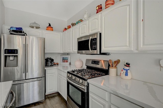 kitchen featuring light stone countertops, white cabinetry, stainless steel appliances, and dark wood-type flooring