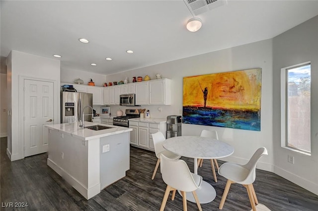 kitchen featuring a kitchen island with sink, white cabinets, sink, dark hardwood / wood-style floors, and appliances with stainless steel finishes