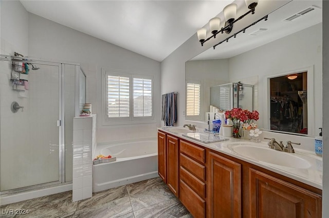 bathroom featuring vanity, shower with separate bathtub, and vaulted ceiling