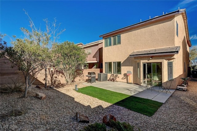 rear view of house featuring central AC unit and a patio