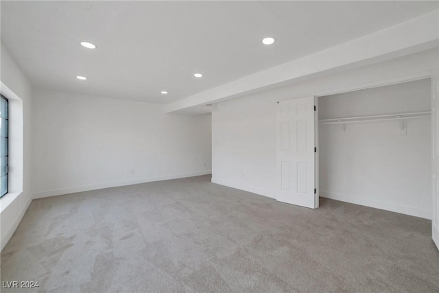 unfurnished bedroom featuring a closet and light carpet