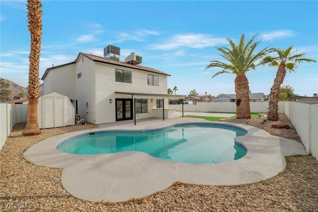 view of pool featuring central AC, a storage shed, and a patio