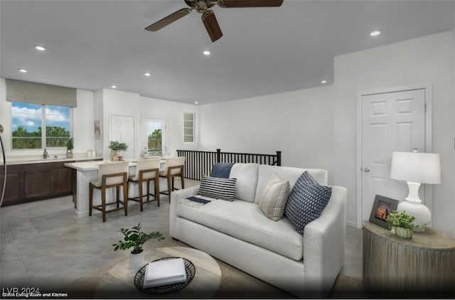 living room featuring ceiling fan, a healthy amount of sunlight, and sink