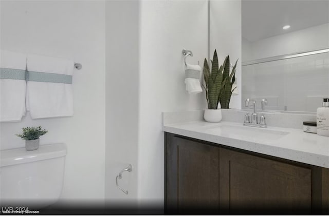 bathroom featuring a shower, vanity, and toilet