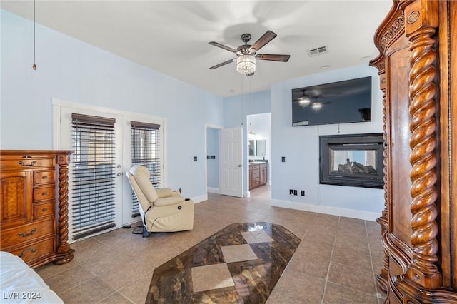 tiled living room featuring a multi sided fireplace and ceiling fan