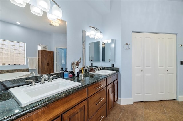 bathroom featuring vanity, tile patterned floors, and a bath